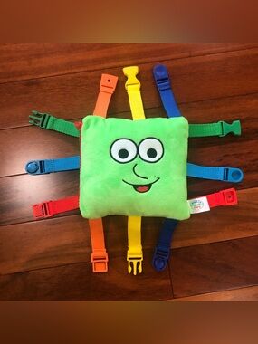 “Buster” Buckle Toy—Green Plush Sensory Buckle Toy with Multicolor Straps